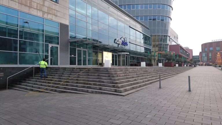 Glasreinigung mit einer Teleskopstange an der Fassade des CityPalais Duisburg.